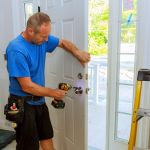 Installation of a lock on the entrance door Hand 's man with screwdriver Installs door knob.